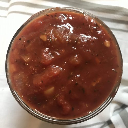 An overhead view of a jar full of marinara sauce