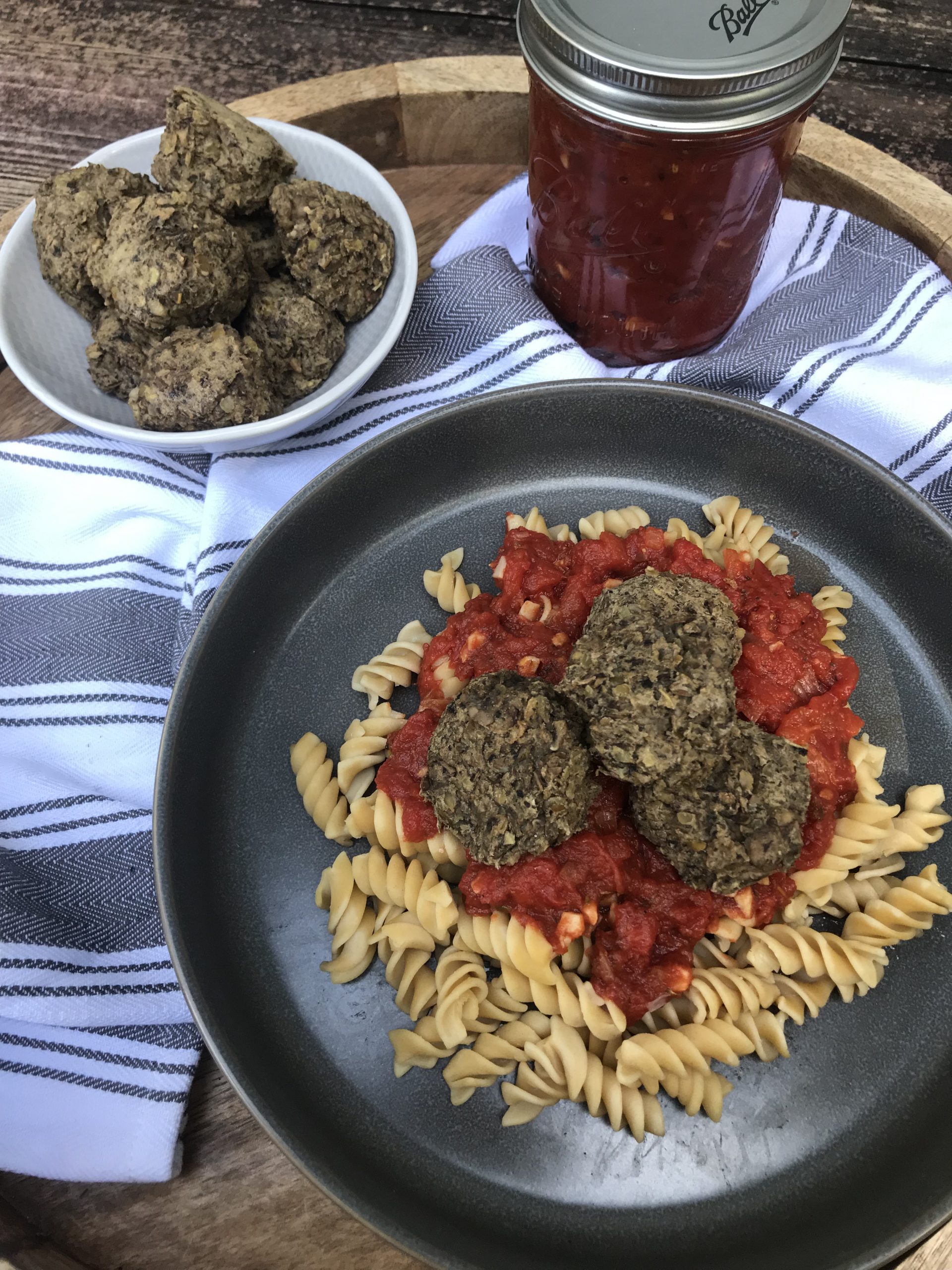 A plate of pasta, marinara sauce, and lentil meatballs on top.