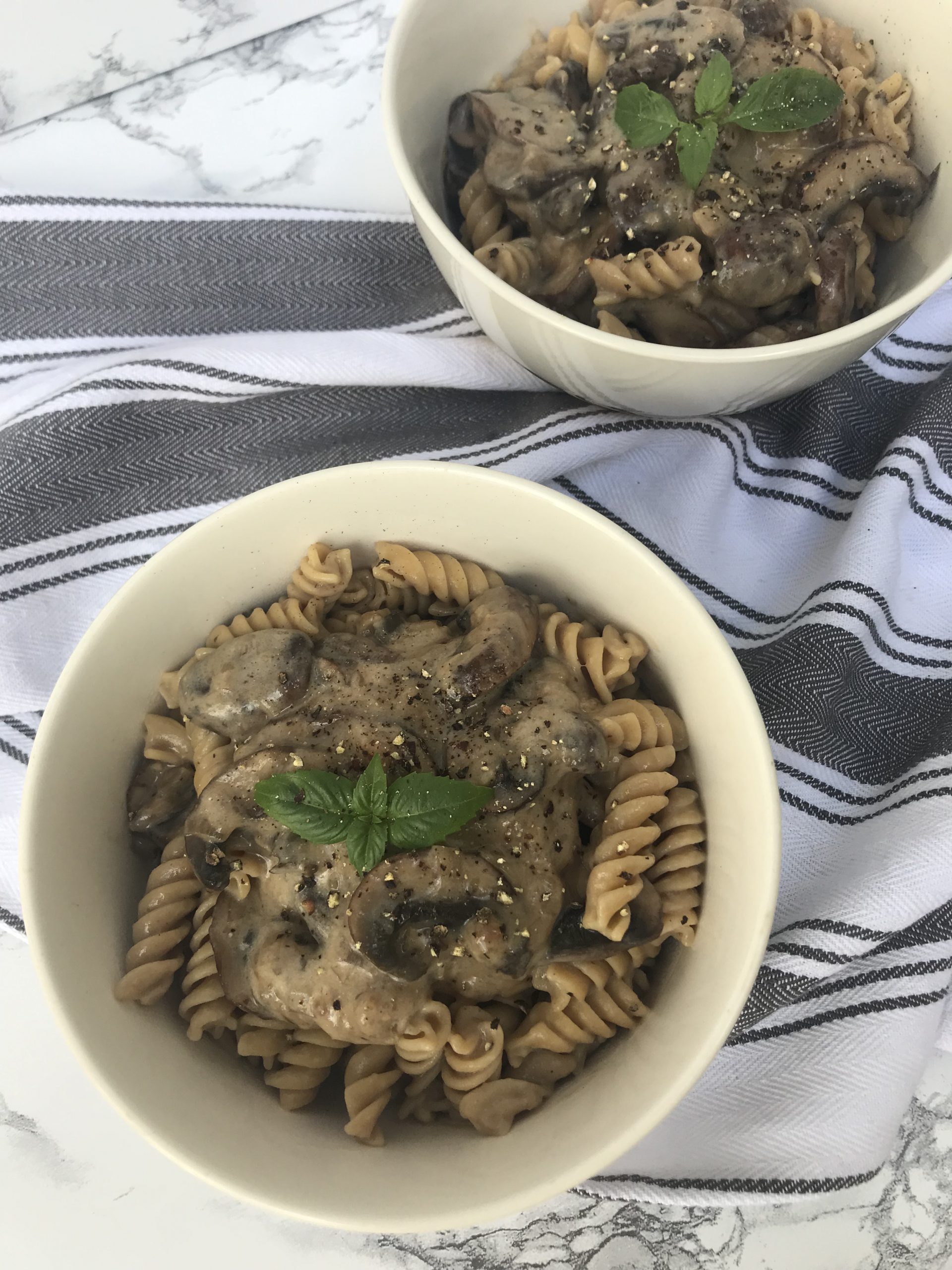 2 bowls of mushroom stroganoff topped with basil