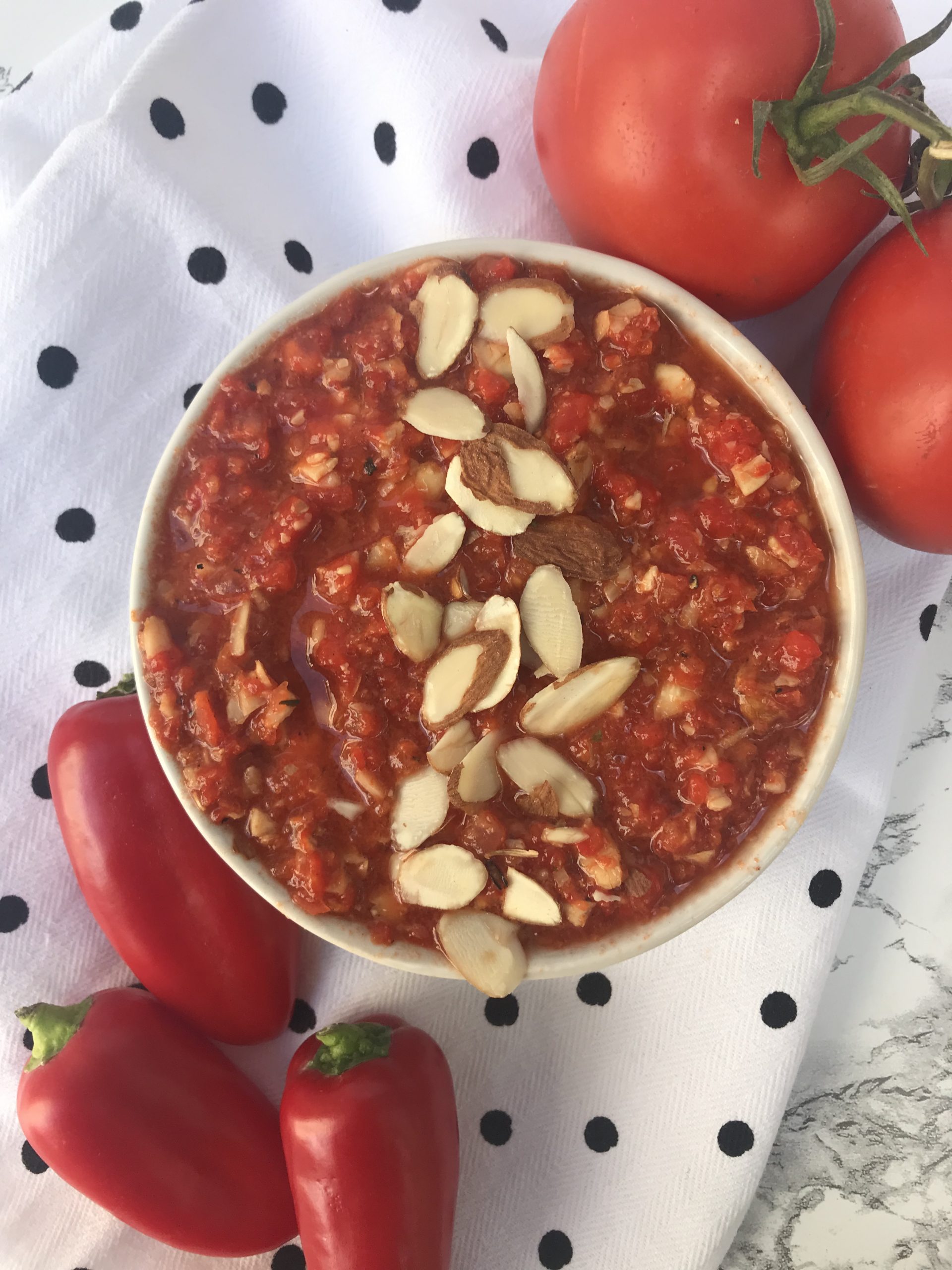 a bowl of romesco sauce with peppers and tomatoes