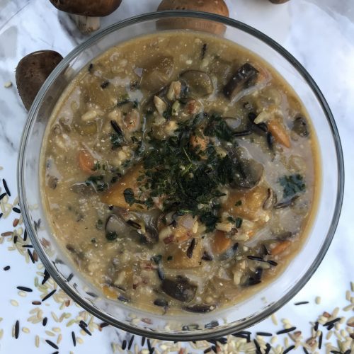 a bowl of wild rice soup topped with fresh basil