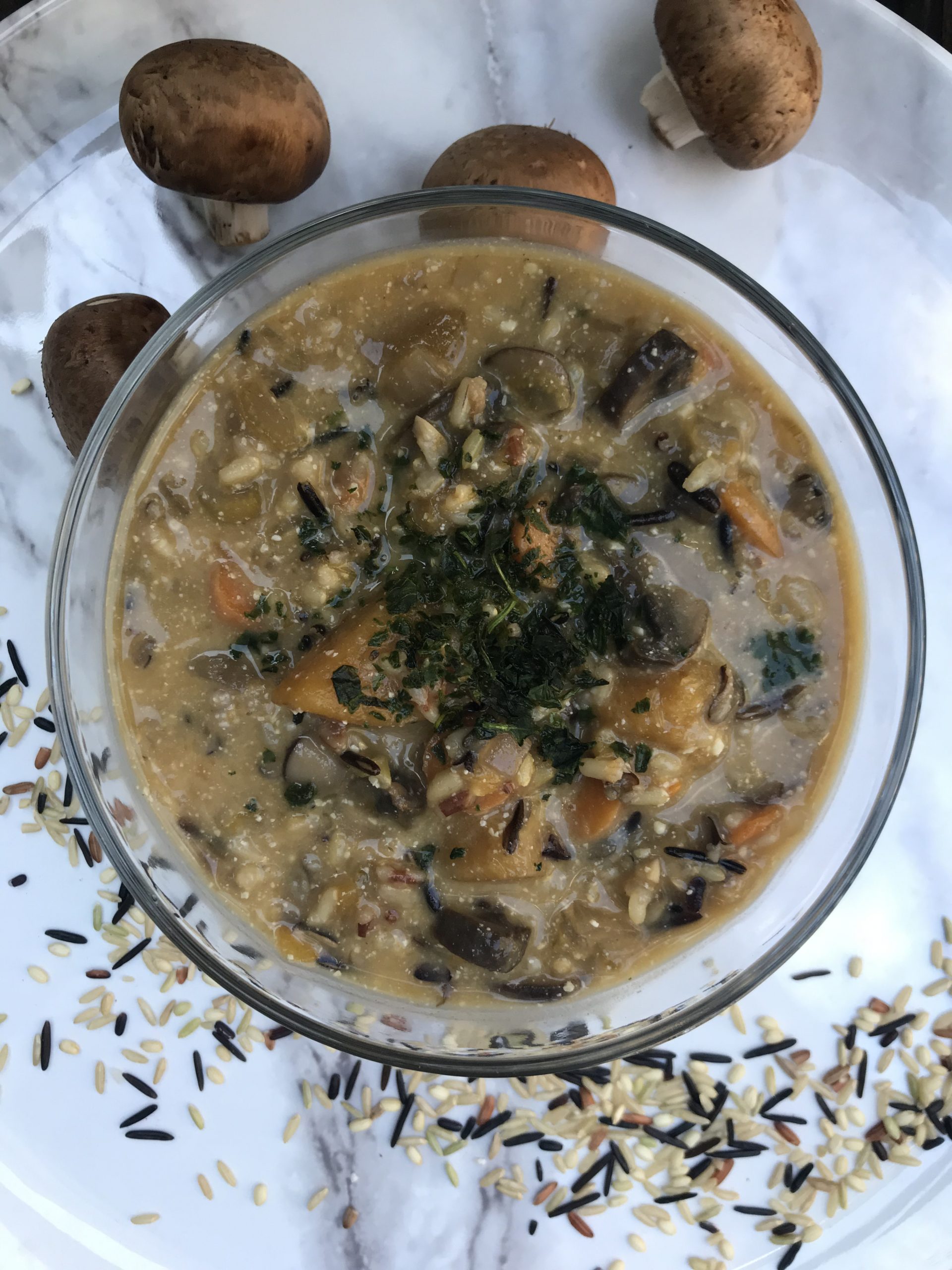 a bowl of wild rice soup topped with fresh basil