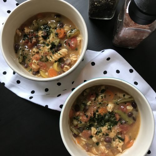 bowls of minestrone soup topped with basil