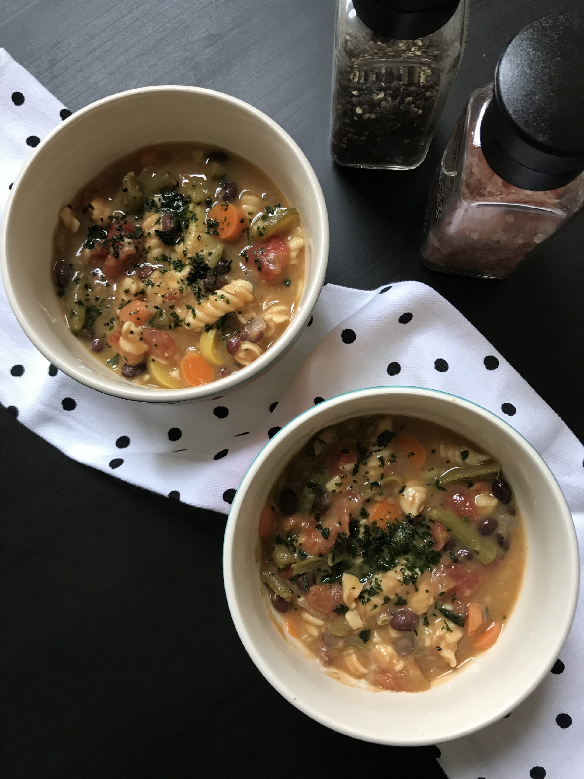 bowls of minestrone soup topped with basil