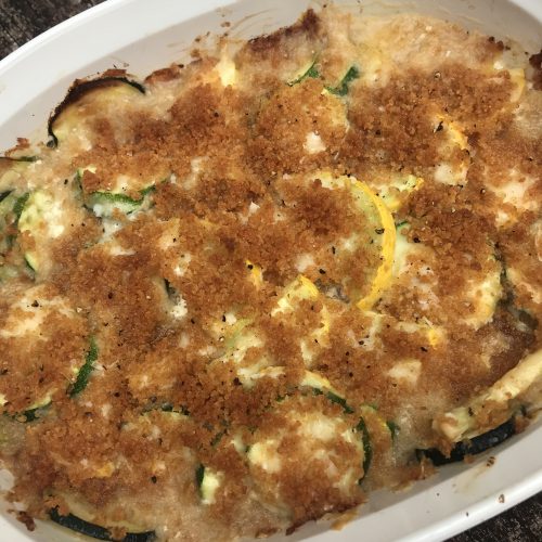 a dish of squash casserole topped with toasted breadcrumbs