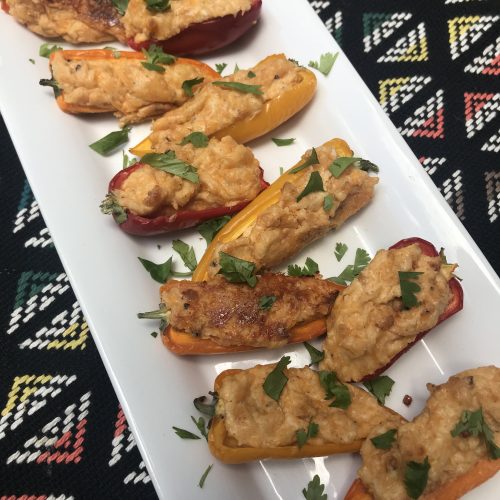 a plate of sweet pepper poppers stuffed with cream cheese and topped with cilantro