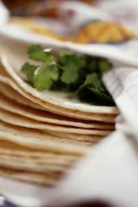 a stack of tortillas with cilantro