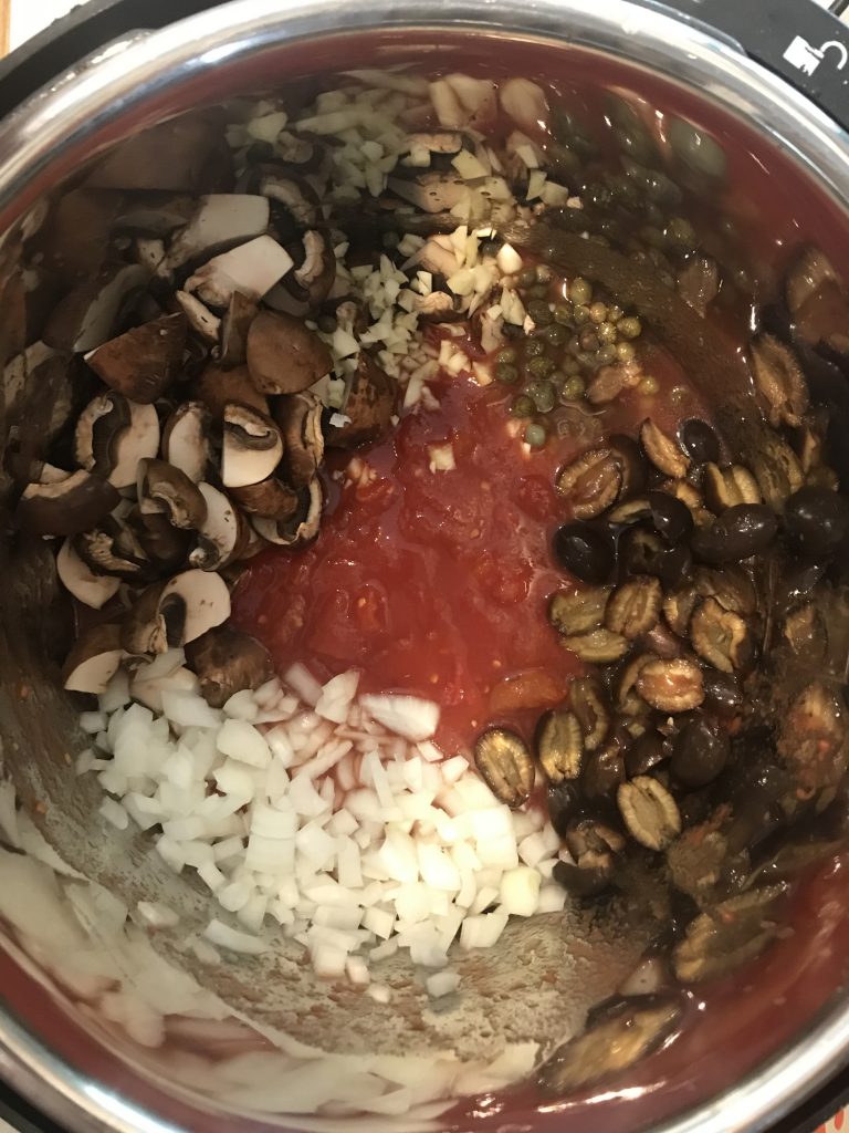 an overhead shot of the pressure cooker with the uncooked ingredients