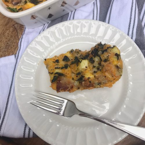 a slice of breakfast casserole on a plate with a fork