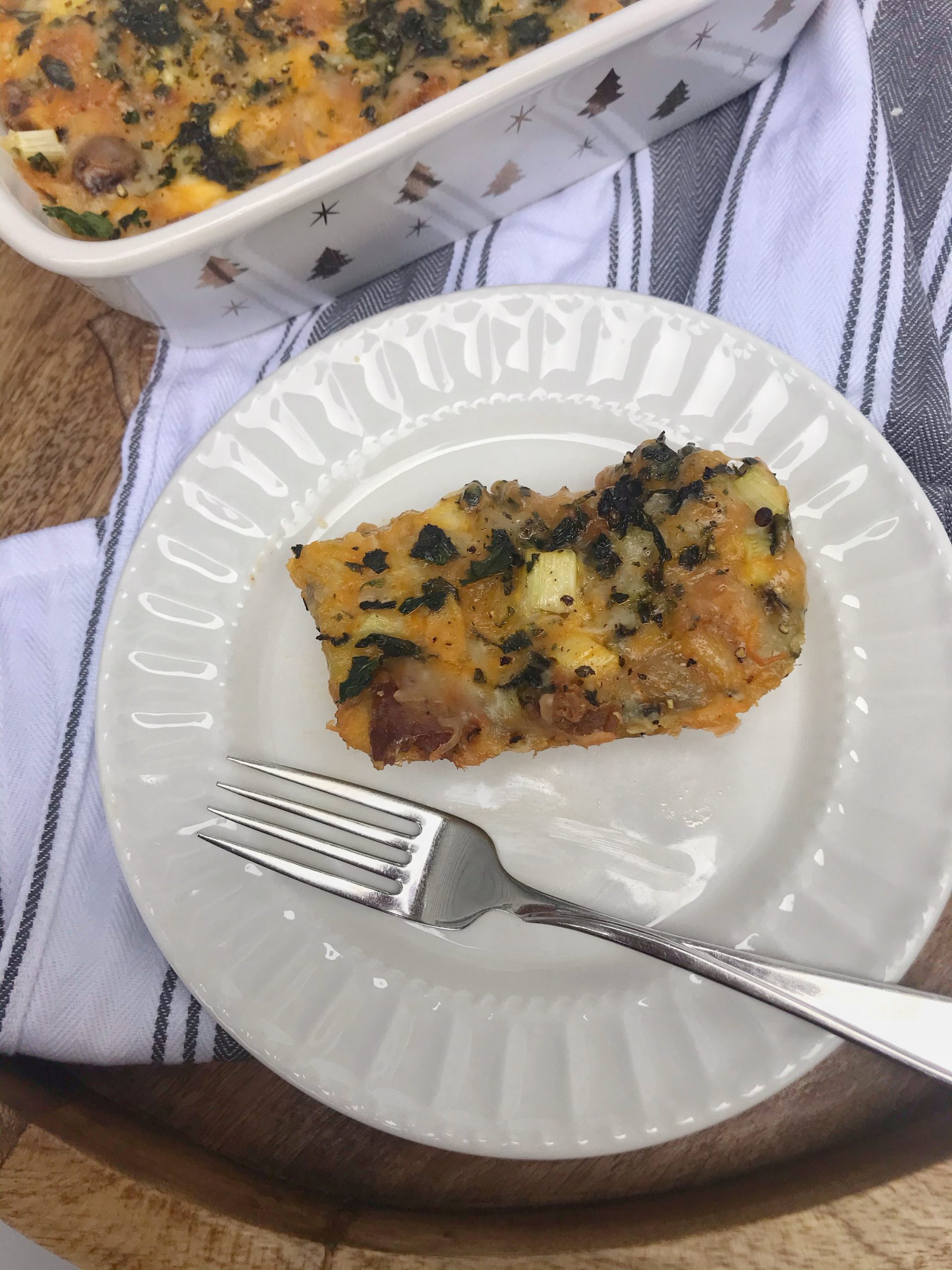 a slice of breakfast casserole on a plate with a fork