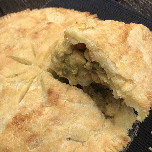 a close up of the pot pie with a spatula taking out a slice of pie