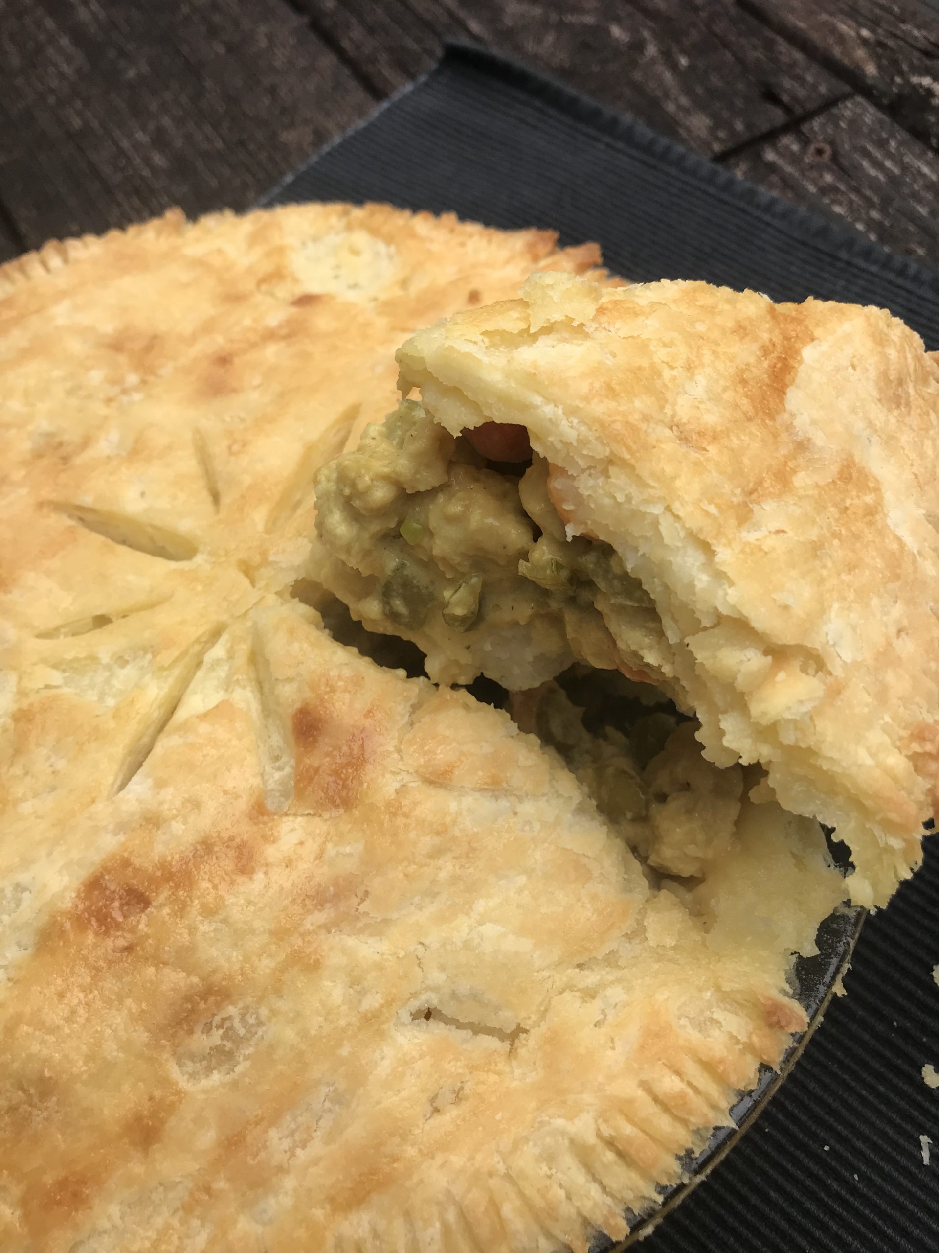 a close up of the pot pie with a spatula taking out a slice of pie