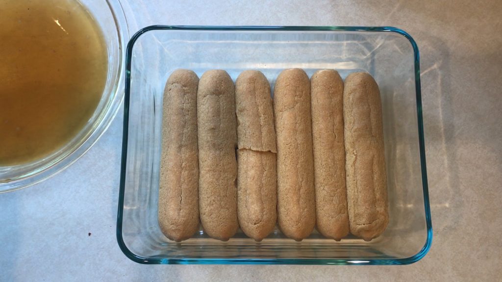 a layer of coffee-soaked lady fingers in a glass dish