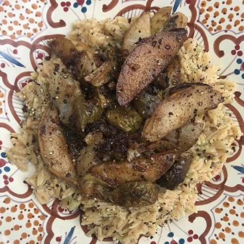 a bowl of orzo with balsamic pears and brussels sprouts