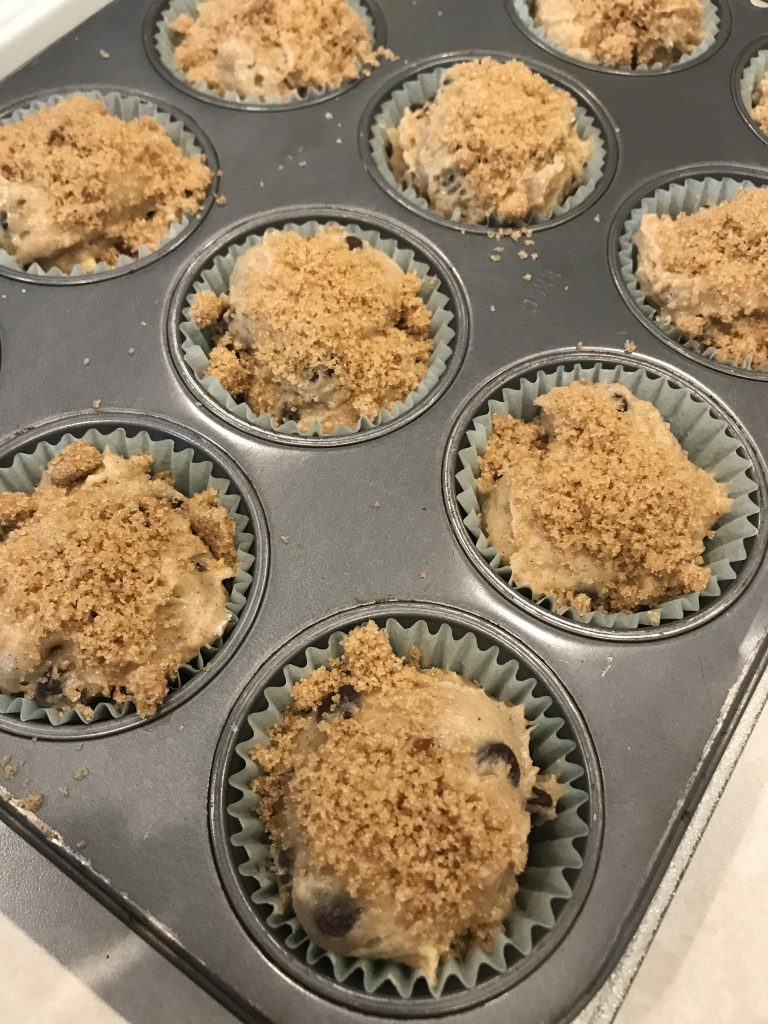 the try of uncooked muffins with brown sugar sprinkled on top